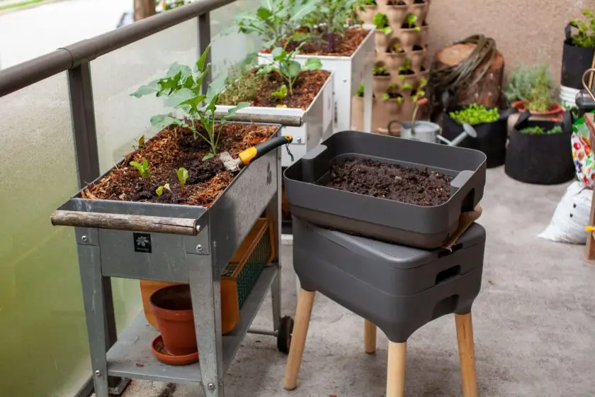 Balkongarten mit Hochbeeten und Wurmkomposter für nachhaltigen Anbau.